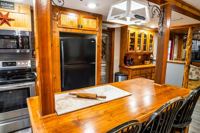 1950 N Crossway Rd, Fair Grove, MO 65648 - kitchen featuring appliances with stainless steel finishes, butcher block counters, ventilation hood, glass insert cabinets, and brown cabinetry