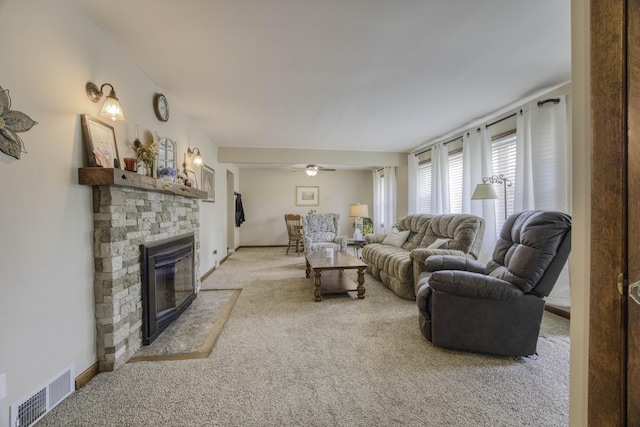 1650 S Fort Ave, Springfield, MO 65807 - living room featuring light colored carpet, a stone fireplace, and a ceiling fan