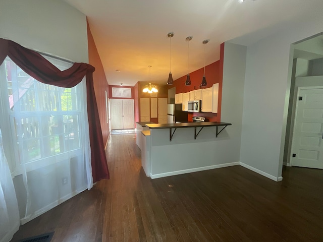 630 W State St, Springfield, MO 65806 - kitchen with stainless steel appliances, dark wood-style flooring, a kitchen breakfast bar, dark countertops, and a peninsula