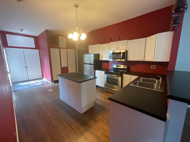 630 W State St, Springfield, MO 65806 - kitchen with stainless steel appliances, dark countertops, a kitchen island, white cabinets, and dark wood-style floors