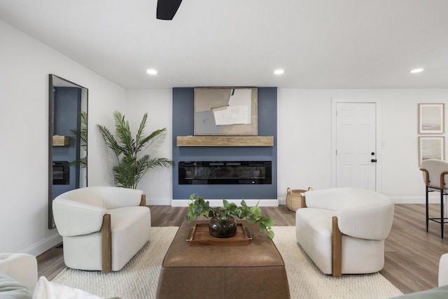 4959 S Mccann Ave, Springfield, MO 65804 - living room featuring wood finished floors, a glass covered fireplace, recessed lighting, and a ceiling fan