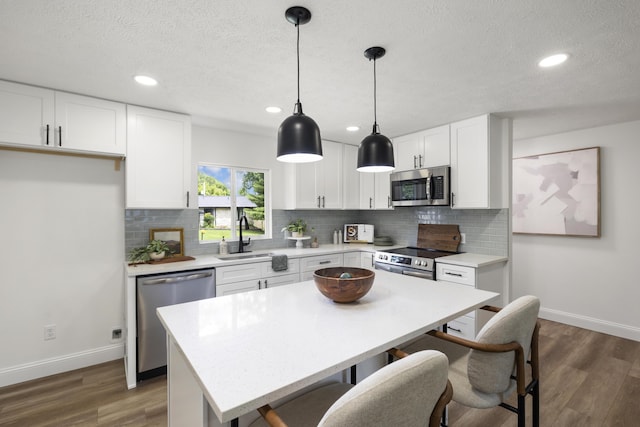 4959 S Mccann Ave, Springfield, MO 65804 - kitchen featuring stainless steel appliances, a breakfast bar area, light countertops, white cabinets, and recessed lighting