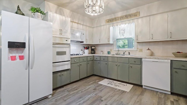 1931 Kay Dr, West Plains, MO 65775 - kitchen featuring white appliances, a warming drawer, light countertops, backsplash, and light wood-style flooring