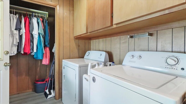 1931 Kay Dr, West Plains, MO 65775 - laundry area with independent washer and dryer, cabinet space, wood walls, and light wood finished floors