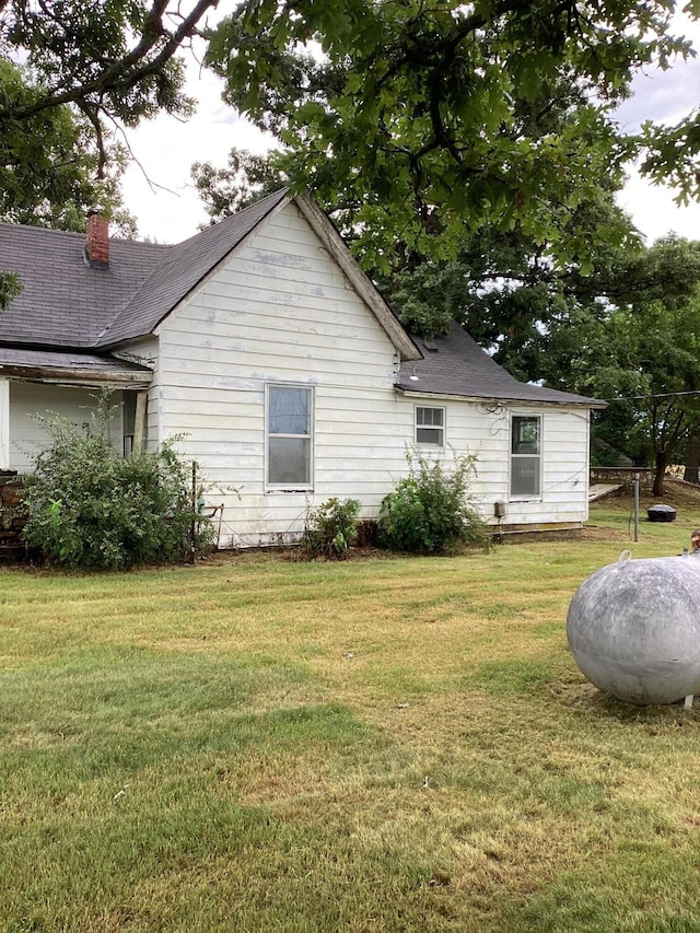 1231 W Main St, Fordland, MO 65652 - view of home's exterior featuring a lawn, a chimney, and roof with shingles