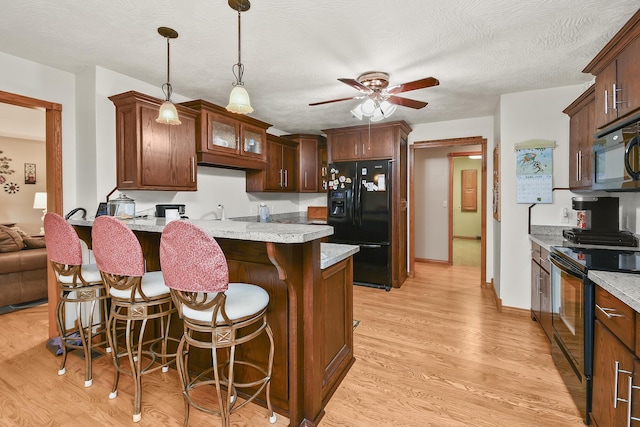 615 W Mchenry Ave, Billings, MO 65610 - kitchen with black appliances, a kitchen breakfast bar, ceiling fan, a peninsula, and hanging light fixtures
