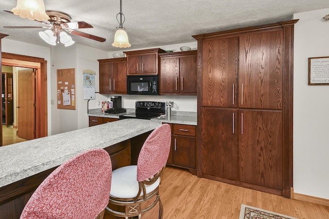 615 W Mchenry Ave, Billings, MO 65610 - kitchen with black appliances, light countertops, a ceiling fan, and light wood-style flooring