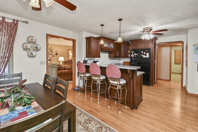 615 W Mchenry Ave, Billings, MO 65610 - kitchen featuring ceiling fan, black refrigerator with ice dispenser, a peninsula, light wood-style floors, and light countertops