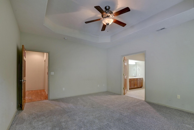 613 Crossing Dr, Branson West, MO 65737 - unfurnished bedroom with light colored carpet, a raised ceiling, ensuite bath, and ceiling fan