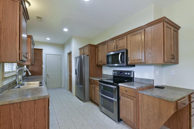 613 Crossing Dr, Branson West, MO 65737 - kitchen featuring appliances with stainless steel finishes, dark countertops, light tile patterned flooring, brown cabinetry, and recessed lighting