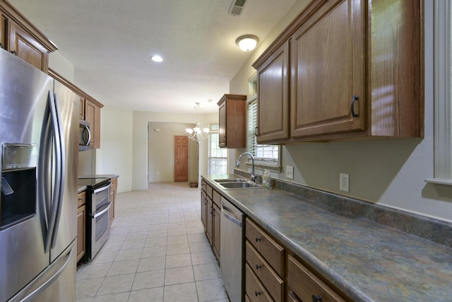 613 Crossing Dr, Branson West, MO 65737 - kitchen with stainless steel appliances, a chandelier, dark countertops, light tile patterned floors, and recessed lighting