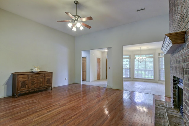 613 Crossing Dr, Branson West, MO 65737 - unfurnished living room with hardwood / wood-style floors, a fireplace, ceiling fan, and a chandelier