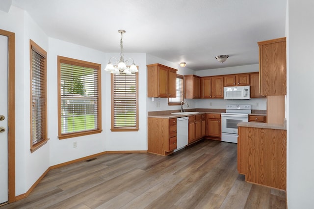 409 Ace Ct, Nixa, MO 65714 - kitchen featuring white appliances, a chandelier, wood finished floors, and plenty of natural light