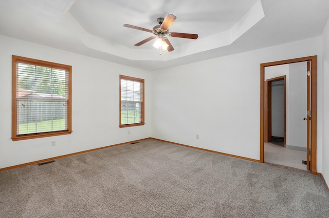 409 Ace Ct, Nixa, MO 65714 - spare room featuring a raised ceiling, healthy amount of natural light, a ceiling fan, and carpet floors