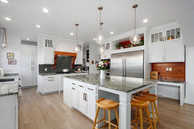 1373 E River Oak Dr, Springfield, MO 65803 - kitchen featuring high end fridge, backsplash, a center island, white cabinets, and light wood-style flooring