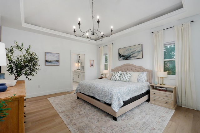 1373 E River Oak Dr, Springfield, MO 65803 - bedroom featuring a tray ceiling, a chandelier, light wood-type flooring, and ensuite bathroom