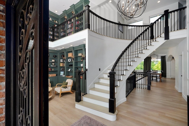 1373 E River Oak Dr, Springfield, MO 65803 - stairs featuring a high ceiling, a chandelier, arched walkways, wood finished floors, and recessed lighting