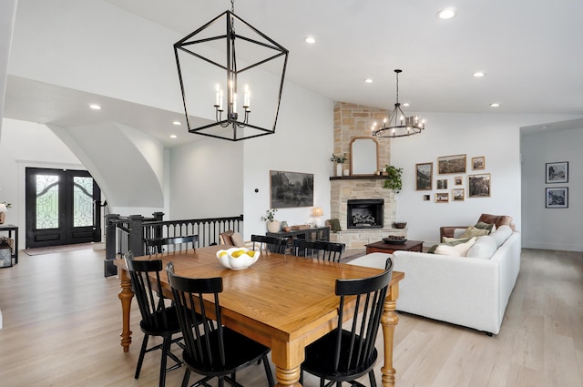 1373 E River Oak Dr, Springfield, MO 65803 - dining space with a chandelier, a stone fireplace, light wood-style flooring, high vaulted ceiling, and recessed lighting