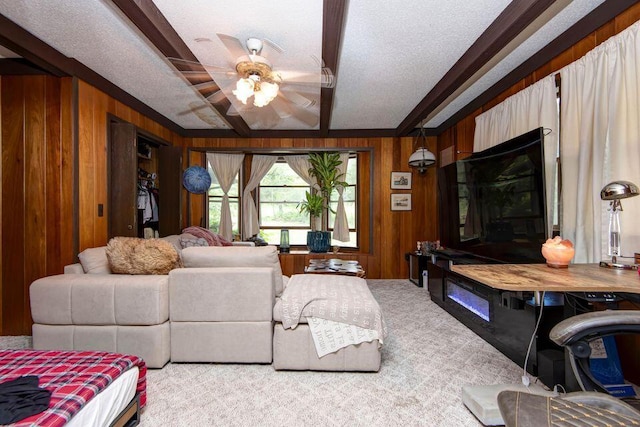 637 State Highway Kk, Cedar Creek, MO 65627 - carpeted living room featuring wooden walls, a ceiling fan, beamed ceiling, crown molding, and a textured ceiling