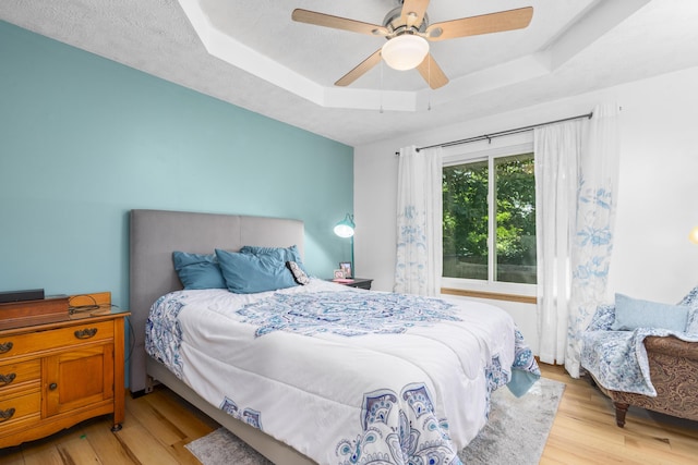 4105 S Oak Ave, Springfield, MO 65804 - bedroom with a tray ceiling, light wood-style floors, and a ceiling fan