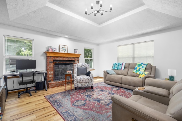 4105 S Oak Ave, Springfield, MO 65804 - living area featuring wood finished floors, a chandelier, a tray ceiling, healthy amount of natural light, and a textured ceiling
