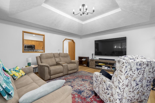 4105 S Oak Ave, Springfield, MO 65804 - living room with a raised ceiling, a chandelier, wood finished floors, arched walkways, and a textured ceiling