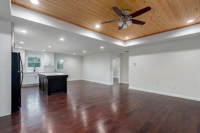 753 S Elm Rd, Marshfield, MO 65706 - unfurnished living room with wooden ceiling, dark wood-type flooring, a ceiling fan, recessed lighting, and a tray ceiling