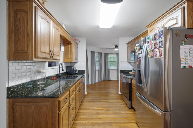 103 Fawn Trl, Neosho, MO 64850 - kitchen with appliances with stainless steel finishes, light wood-type flooring, backsplash, ceiling fan, and dark stone countertops