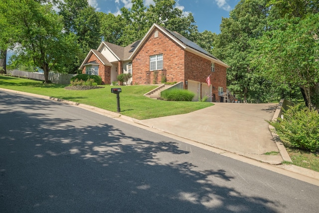 103 Fawn Trl, Neosho, MO 64850 - traditional-style home with brick siding, roof mounted solar panels, concrete driveway, and an attached garage