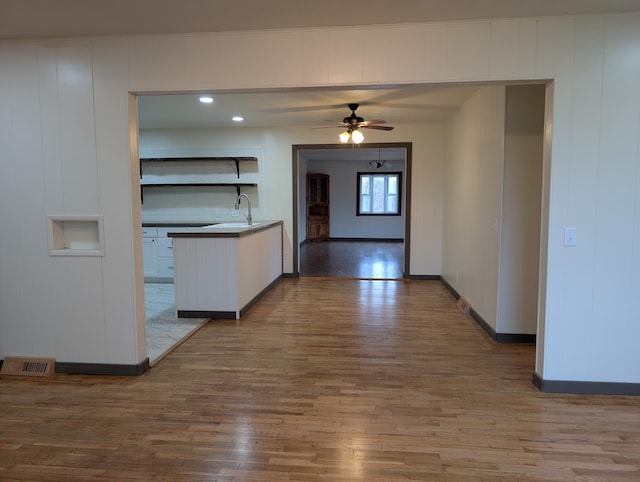 600 N Main St, Pleasant Hope, MO 65725 - kitchen featuring wood finished floors, a ceiling fan, open shelves, and white cabinetry