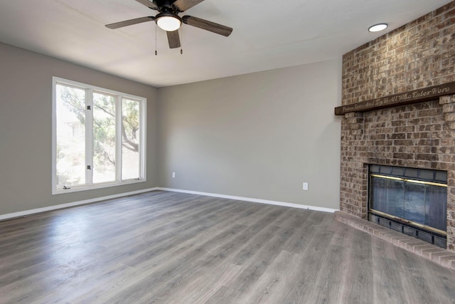 3229 W Hanover St, Springfield, MO 65807 - unfurnished living room with a brick fireplace, a ceiling fan, and wood finished floors
