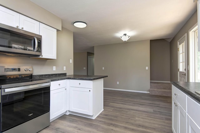 3229 W Hanover St, Springfield, MO 65807 - kitchen with stainless steel appliances, dark countertops, white cabinetry, and dark wood-type flooring