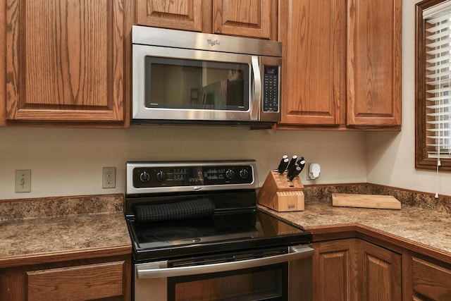 760 S 21st Ave, Ozark, MO 65721 - kitchen with stainless steel appliances, brown cabinetry, and dark countertops
