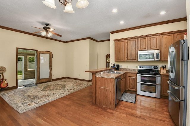 760 S 21st Ave, Ozark, MO 65721 - kitchen featuring stainless steel appliances, a peninsula, brown cabinets, light wood-style flooring, and recessed lighting