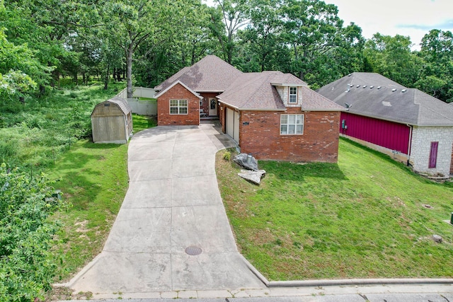 760 S 21st Ave, Ozark, MO 65721 - view of front of home with brick siding, concrete driveway, a storage shed, a garage, and view of wooded area