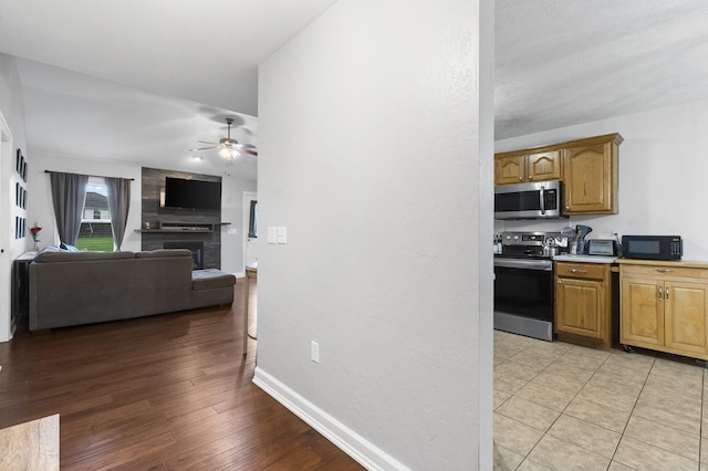 3262 E Colonial St, Republic, MO 65738 - kitchen featuring stainless steel appliances, ceiling fan, light wood-style floors, a fireplace, and light countertops