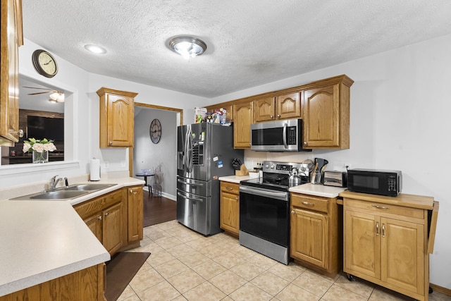 3262 E Colonial St, Republic, MO 65738 - kitchen featuring stainless steel appliances, light countertops, light tile patterned flooring, a textured ceiling, and brown cabinets