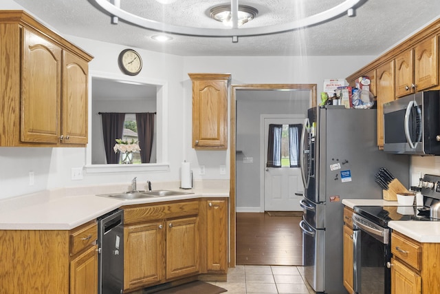 3262 E Colonial St, Republic, MO 65738 - kitchen featuring stainless steel appliances, light tile patterned flooring, light countertops, a textured ceiling, and brown cabinetry