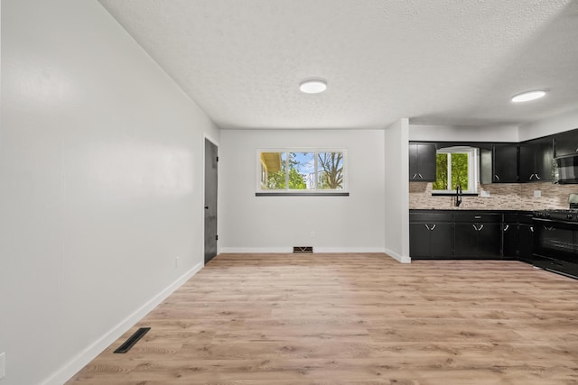 302 W Howard Ave, Billings, MO 65610 - kitchen with black appliances, dark cabinets, light countertops, a textured ceiling, and tasteful backsplash