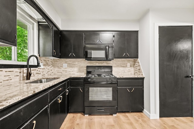 302 W Howard Ave, Billings, MO 65610 - kitchen with black appliances, light wood-style floors, decorative backsplash, and dark cabinets