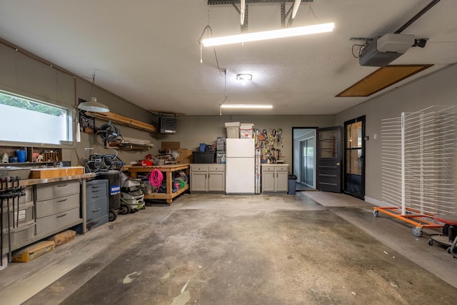 1119 S Cedarbrook Ave, Springfield, MO 65804 - garage featuring freestanding refrigerator, a workshop area, and a garage door opener