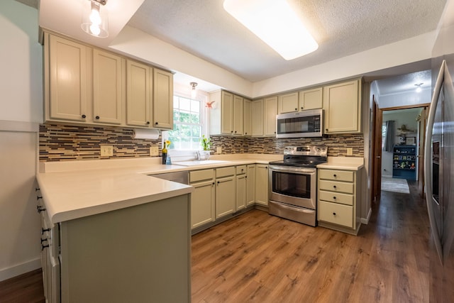 1119 S Cedarbrook Ave, Springfield, MO 65804 - kitchen featuring stainless steel appliances, backsplash, light wood finished floors, light countertops, and a textured ceiling