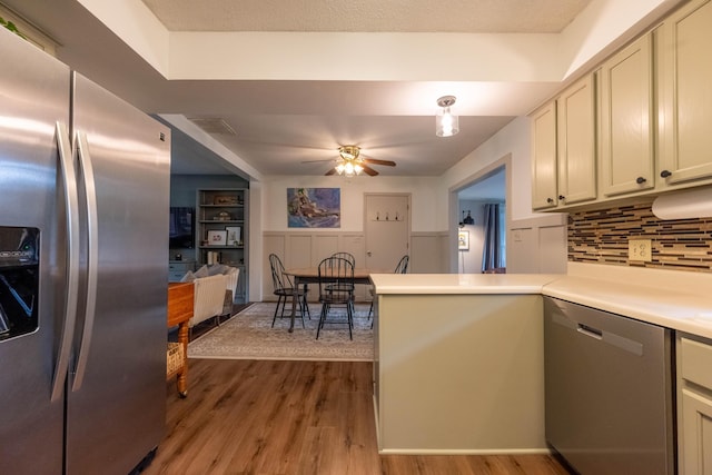 1119 S Cedarbrook Ave, Springfield, MO 65804 - kitchen featuring appliances with stainless steel finishes, light wood-style flooring, a peninsula, ceiling fan, and backsplash