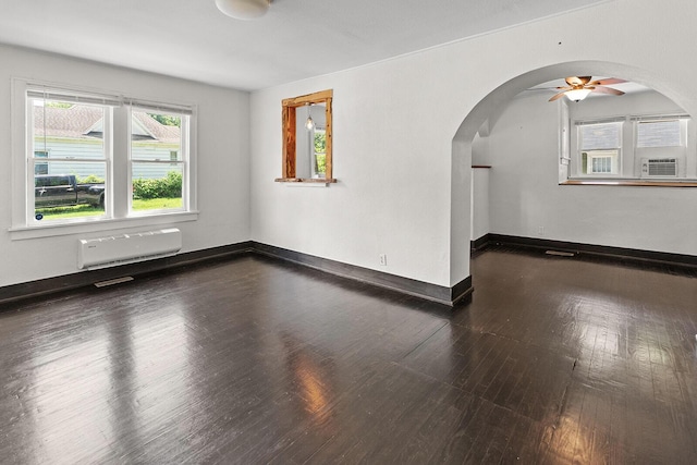 2101 N Main Ave, Springfield, MO 65803 - empty room with arched walkways, wood finished floors, ceiling fan, and a wall mounted AC
