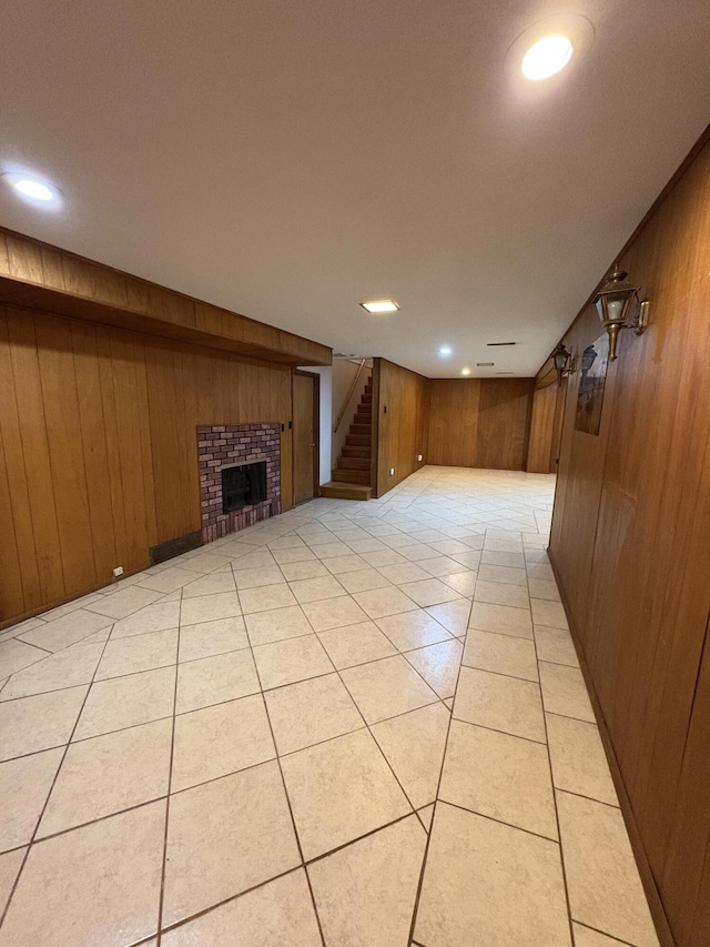 311 Crestwood Dr, Neosho, MO 64850 - unfurnished living room featuring wooden walls, a fireplace, light tile patterned floors, stairway, and recessed lighting