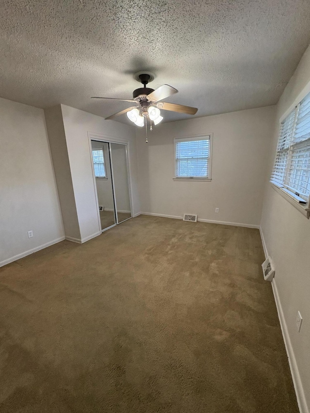 311 Crestwood Dr, Neosho, MO 64850 - unfurnished bedroom with a textured ceiling, carpet flooring, a closet, and ceiling fan