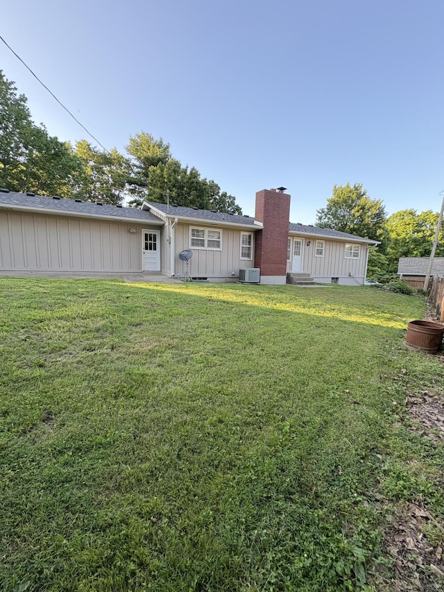 311 Crestwood Dr, Neosho, MO 64850 - rear view of property featuring board and batten siding, a chimney, a lawn, and entry steps