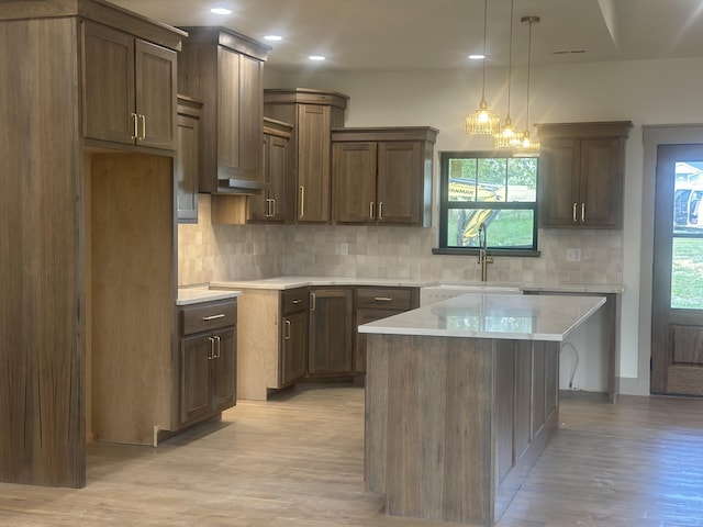 1988 Morris Rd Unit B, Mountain Grove, MO 65711 - kitchen with tasteful backsplash, light wood-style floors, light countertops, a center island, and decorative light fixtures