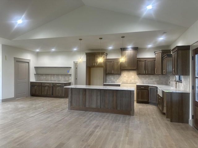 1988 Morris Rd Unit B, Mountain Grove, MO 65711 - kitchen featuring a kitchen island, backsplash, dark brown cabinets, light wood-style flooring, and light countertops