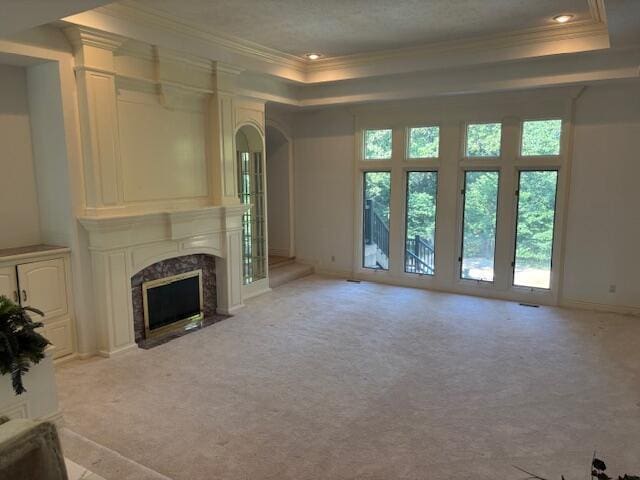 5043 S Glenhaven Ave, Springfield, MO 65804 - unfurnished living room with a raised ceiling, ornamental molding, light colored carpet, a premium fireplace, and arched walkways